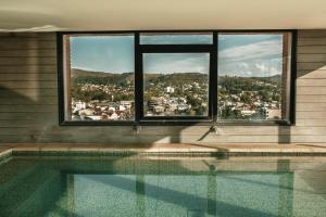una piscina con vista sulla città da una finestra di Mulen Hotel Tandil a Tandil