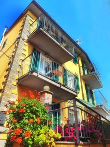a yellow building with balconies and flowers in front of it at Pietra Di Mare in Biassa