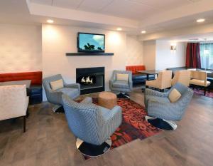 a lobby with a fireplace and chairs and a table at Hampton Inn Raleigh Capital Blvd North in Raleigh