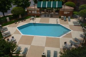 - une vue sur une piscine avec des chaises et un bâtiment dans l'établissement Hampton Inn Raleigh Capital Blvd North, à Raleigh