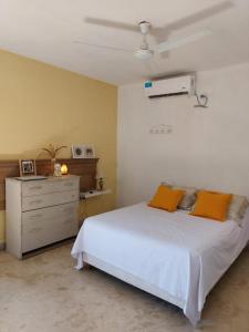 ein Schlafzimmer mit einem weißen Bett und einer Kommode in der Unterkunft Casa country al lado de la montaña! in Santa Rosa