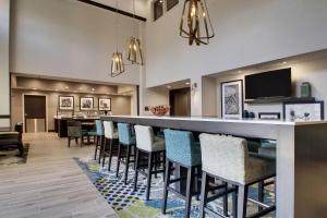 a lobby with a bar with chairs and a television at Hampton Inn & Suites By Hilton Knightdale Raleigh in Raleigh