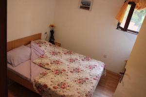 ein Schlafzimmer mit einem Bett mit geblümter Tagesdecke in der Unterkunft Apartments Toni in Trogir