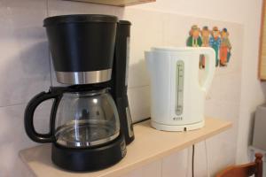 eine Kaffeemaschine, die auf einem Regal neben einem Mixer steht in der Unterkunft Apartments Toni in Trogir