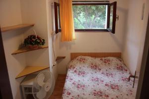 ein kleines Schlafzimmer mit einem Bett und einem Fenster in der Unterkunft Apartments Toni in Trogir