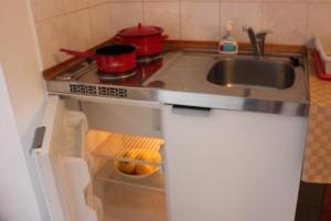 eine kleine Küche mit Spüle und Herd in der Unterkunft Apartments Toni in Trogir + 10 Fotos