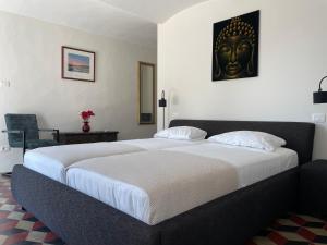 a bedroom with a large bed with a black mask on the wall at Tenuta Dei Vicini - Luxury Apartments in San Marzano Oliveto