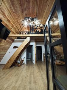ein Loft-Zimmer mit einer Treppe in einem Haus in der Unterkunft Cabana JagerBerg Rosenau in Râșnov