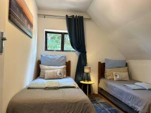 1 Schlafzimmer mit 2 Betten und einem Fenster in der Unterkunft Big Fish Seaside Cottage, Sleeps 10 Guests in 5 Bedrooms in Port Edward
