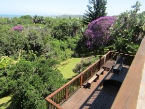 a wooden walkway with benches on top of avisorukongukongukongukongukong at Big Fish Seaside Cottage, Sleeps 10 Guests in 5 Bedrooms in Port Edward