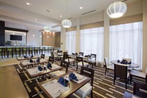 a restaurant with tables and chairs and a bar at Hilton Garden Inn Raleigh Cary in Cary