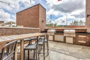 una gran cocina al aire libre con mesa de madera y taburetes en Home2 Suites By Hilton Raleigh State Arena, en Raleigh