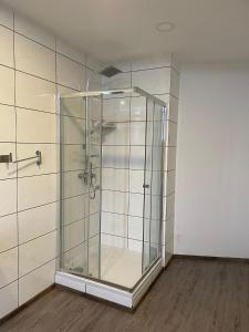 a glass shower in a room with a wooden floor at Eventhaus in Panzweiler