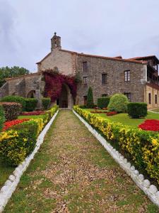 un grand bâtiment en briques avec des fleurs devant lui dans l'établissement El Faro de la Barquera, à San Vicente de la Barquera