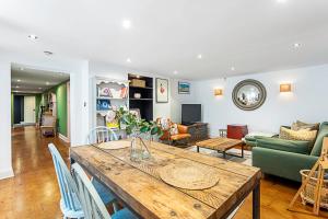 uma sala de estar com uma mesa e um sofá em Cottage Style Three Bedroom House em Londres