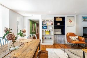 uma sala de estar com uma mesa de madeira e cadeiras em Cottage Style Three Bedroom House em Londres