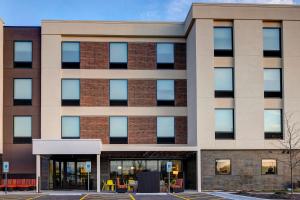 a large brick building with windows at Home2 Suites By Hilton DeKalb in DeKalb