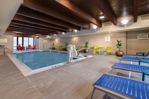 uma grande piscina com bancos azuis num quarto de hotel em Home2 Suites By Hilton DeKalb em DeKalb