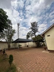 a black canopy in a parking lot next to a building at Deer Hotel in Kigali
