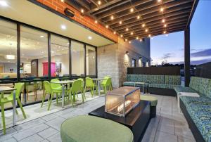 a restaurant with green chairs and tables and windows at Home2 Suites By Hilton Raleigh Durham Airport RTP in Durham