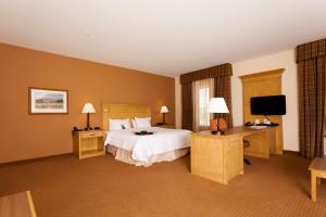 リバートンにあるHampton Inn & Suites Rivertonのベッドとテレビが備わるホテルルームです。