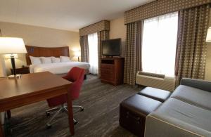 Hampton Inn & Suites Richmond/Virginia Center في ريتشموند: غرفة الفندق بسرير ومكتب واريكة