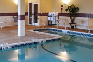 a swimming pool in a room with a table and chairs at Hampton Inn & Suites Rockland in Thomaston