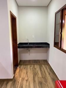 a bathroom with a sink and a wooden floor at Chalés Vista da Serra in Piumhi