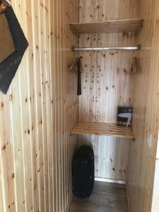 a room with a wooden wall with a shelf and a suitcase at Neadín Beag in Tralee