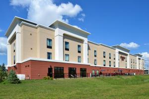 a large building with a grass field in front of it at Hampton Inn Rome in Rome