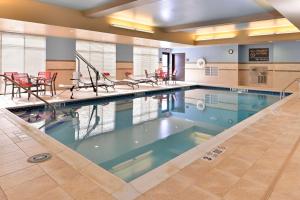 a large swimming pool with red tables and chairs at Hampton Inn Rome in Rome