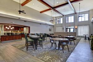 a lobby with tables and chairs and a kitchen at Homewood Suites by Hilton Reno in Reno