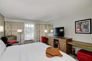 a hotel room with a bed and a flat screen tv at Hampton Inn Salem in Salem