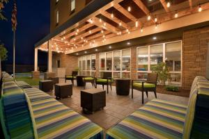 eine Terrasse mit Stühlen, Tischen und Lampen in der Unterkunft Home2 Suites by Hilton Roanoke in Roanoke