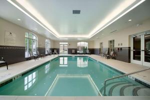 a large swimming pool with blue water in a building at Homewood Suites by Hilton Rochester/Greece, NY in Rochester