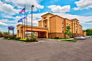 a hotel with two flags in a parking lot at Hampton Inn Rochester - Irondequoit in Rochester