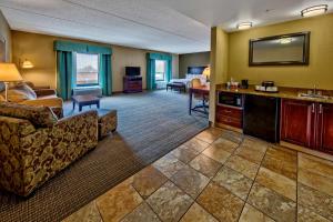 um quarto de hotel com uma sala de estar com um sofá e cadeiras em Hampton Inn Rochester - Irondequoit em Rochester
