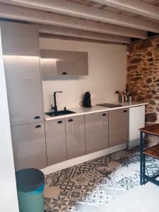 - une cuisine avec des placards blancs et un évier dans l'établissement La Gavina, à Beáriz