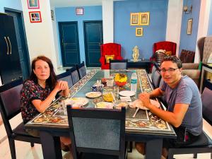 Ein Mann und eine Frau sitzen an einem Tisch in der Unterkunft Shiv Kothi - Homestay in Agra