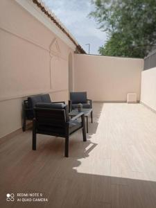 twee stoelen en een tafel op een patio bij Piso a 5 min de la Alhambra in Granada