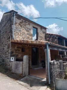 Elle offre une vue sur une maison en pierre dotée d'une terrasse couverte en bois. dans l'établissement La Gavina, à Beáriz