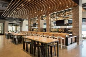 a restaurant with tables and chairs and a bar at Hilton Garden Inn Rochester - University & Medical Center in Rochester