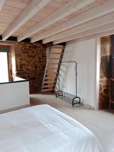 Un dormitorio con una cama blanca y una pared de ladrillo. en La Gavina, en Beáriz