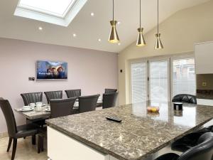 ein Esszimmer mit einem Tisch und Stühlen in der Unterkunft New Luxury Modern House near Airport Free Parking in Luton