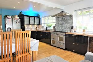 a kitchen with stainless steel appliances and black cabinets at Lavender House, Fleet in Fleet