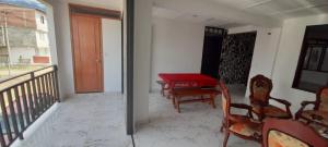 a room with a red table and chairs on a balcony at Apartamento Jardín Colombiano in Calima