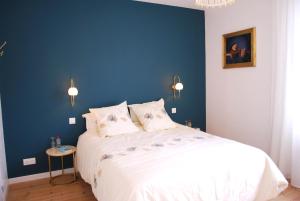 a bedroom with a large bed with a blue wall at Maison Coté Jardin Amiens - Longueau in Longueau