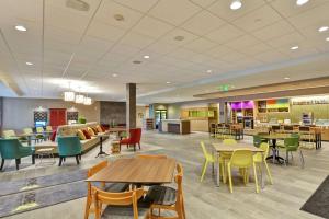 a lobby of a hospital with tables and chairs at Home2 Suites by Hilton Rochester Mayo Clinic Area in Rochester