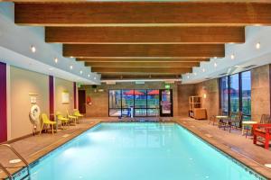 a pool in a hotel lobby with tables and chairs at Home2 Suites by Hilton Rochester Mayo Clinic Area in Rochester