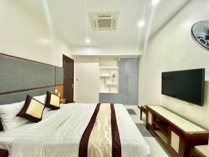 1 dormitorio con 1 cama grande y TV de pantalla plana en In Le Hotel & Apartments, en Hai Phong
